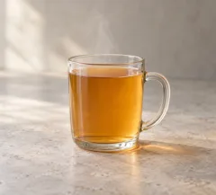 Jus de pomme chaud ambré dans une tasse, infusion filtrée sans morceaux