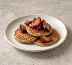 Trois pancakes au sarrasin garnis de quartiers de prunes poêlées