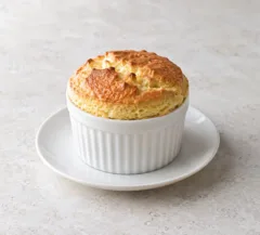 Soufflé individuel à la poire et au gingembre, dessus doré au-dessus du ramequin